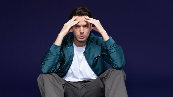 Czym jest kredyt konsumencki? Młody zmartwiony mężczyzna siedzący na podłodze i trzymający się za głowę