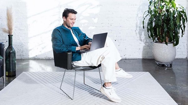 Budżet miesięczny: Co to jest i dlaczego jest przydatny? Młody człowiek pracuje przy laptopie i planuje swój budżet.