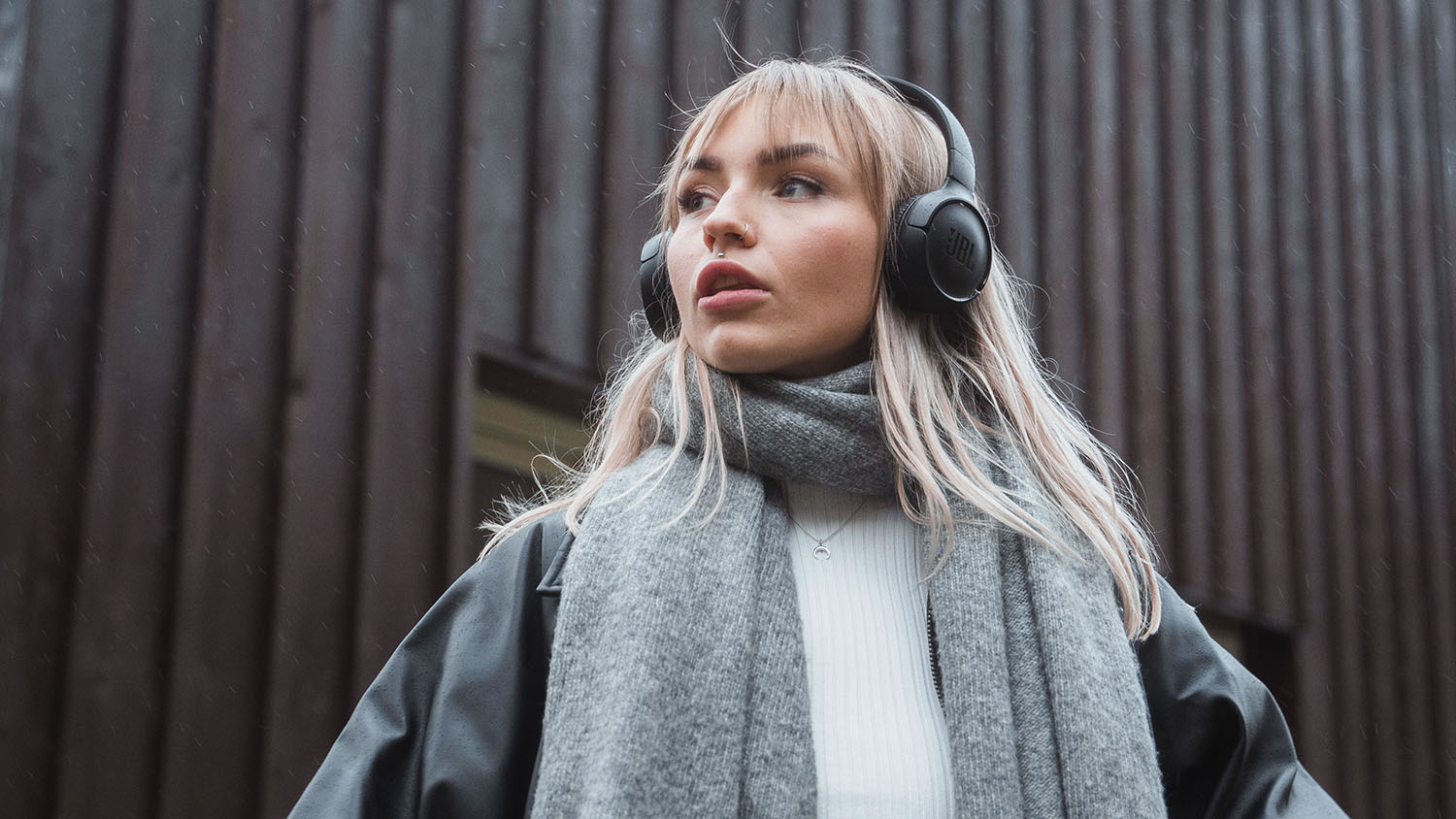 Budowanie bogactwa za niewielkie pieniądze: Od czego zacząć Młoda kobieta ze słuchawkami patrząca w dal