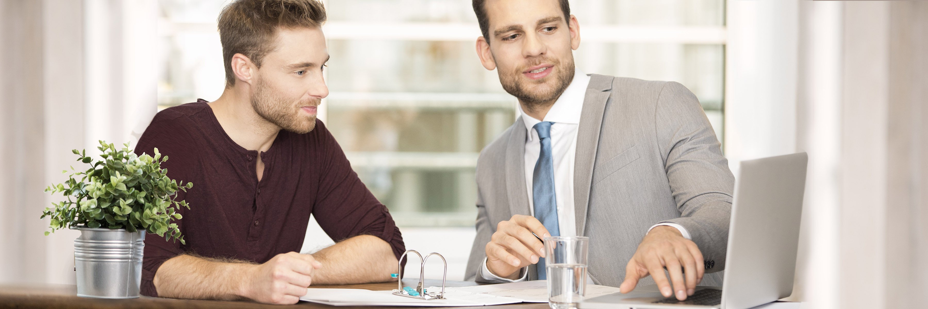 »Doradzamy indywidualnie.« Doradca finansowy pokazuje klientowi coś na laptopie.