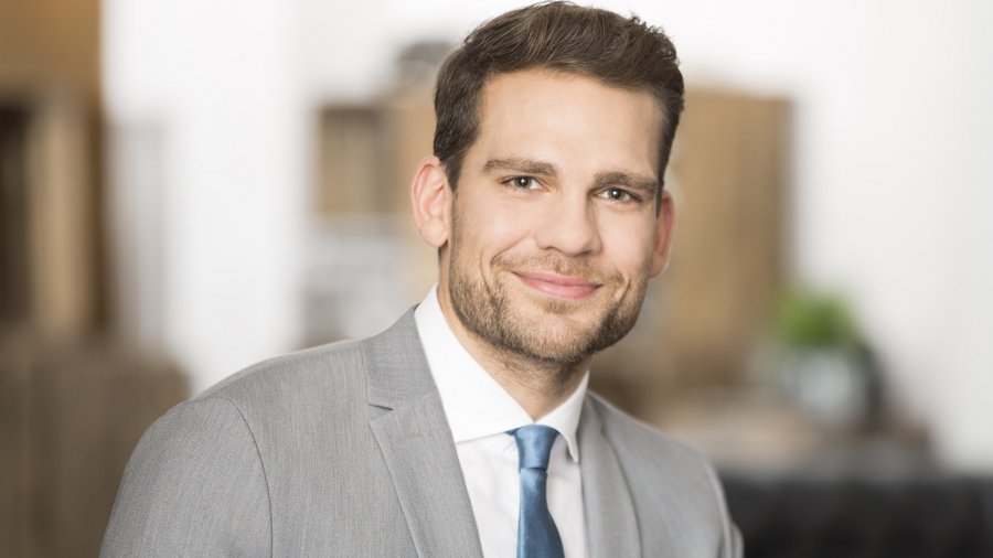 Tomasz W., Pośrednik finansowy Uśmiechnięty pośrednik finansowy w garniturze