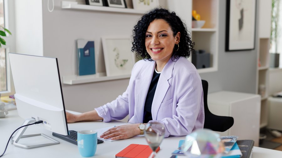 Kontakt Kobieta w miejscu pracy w biurze uśmiecha się do kamery.